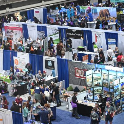 a birds eye view of booths and crowds of participants at the expo exhibit hall